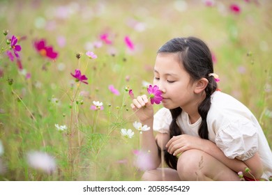 Girl Smelling The Scent Of Flowers