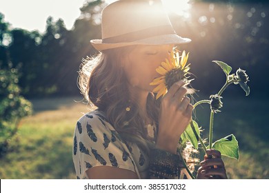 Girl smells sunflower in nature