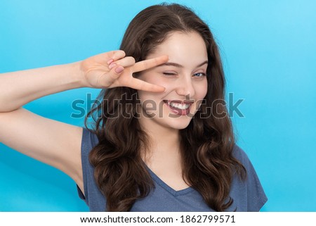 Girl smiles and shows peace sign