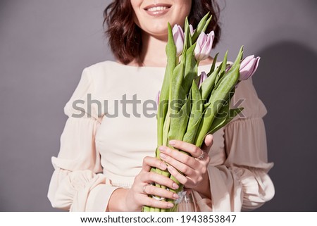 Girl is smiling with beautiful bouquet of tulips n grey background Foto stock © 