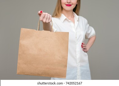 girl smiling, holding a package in his hand, with the purchase, mockup, background, with copy space, for advertising