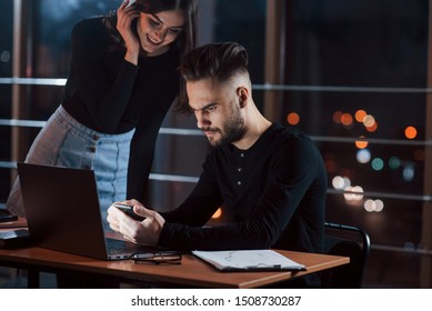 Girl is smiling. Team of young business people works on their project at night time in the office. - Shutterstock ID 1508730287