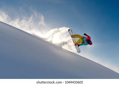 Girl Snowboarder Jumping Front Flip Leaving Behind A Wave Of Snow