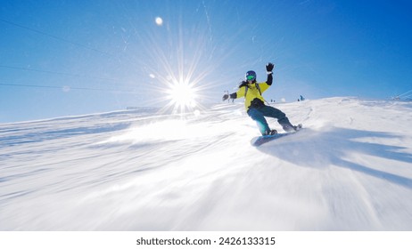 Girl snowboarding on slopes. Sun rays and flare visible. - Powered by Shutterstock