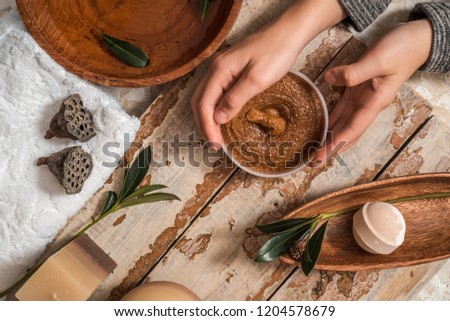 The girl in the spa center. Hand scrub care. Brown sugar with honey, chocolate. Candles and white towel. Dry lily fruits. Green branch of fruit. The concept of spa and health. Flat lay, top view.