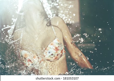 Girl Splashing Water Out Of A Pool