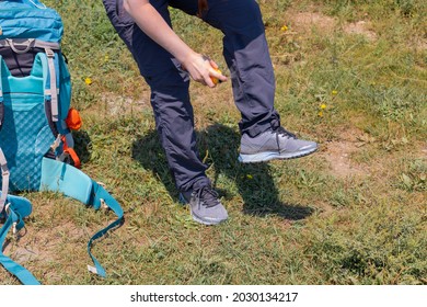 The Girl Sprays Her Pants With A Spray From Ticks. The Concept Of Mountain Hiking In The Wild. The Concept Of Protection Against Ticks