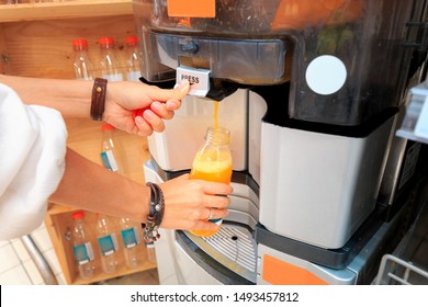 Girl squeezes juice in a juicer in the supermarket - Powered by Shutterstock