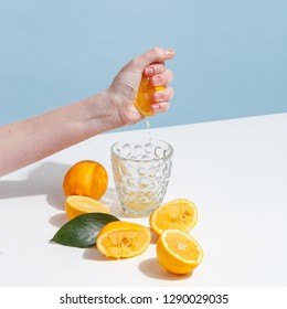 The girl squeezes the juice from a lemon into a glass. - Powered by Shutterstock