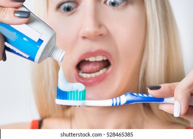 Girl Squeezing Toothpaste On The Brush