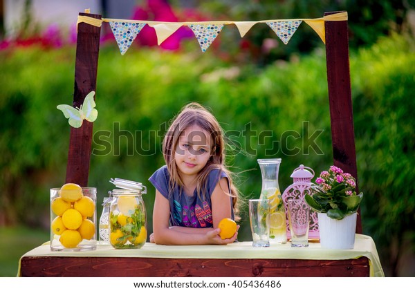 Girl stand at the lemonade\
stand