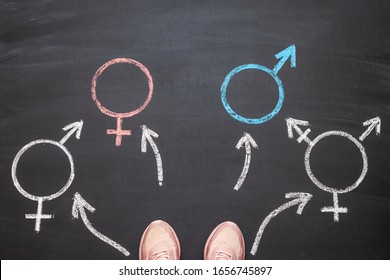 A Girl Standing Before A Choice Of Gender Symbols Of Male, Female, Bigender And Transgender. Concept Of Choice Or Gender Confusion Or Dysphoria.