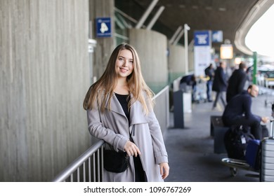 Girl standing near railway station in grey coat. Concept of business trip and traveling. - Shutterstock ID 1096767269