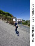 girl standing on Baldwin Street - the steepest street in the world, Dunedin, New Zealand, South Island