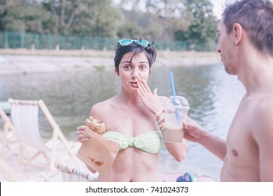 Girl Standing On A Beach Eating Burger, Boy Offering Milkshake