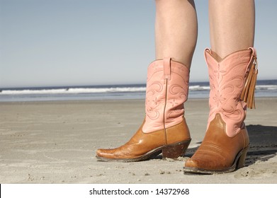 girl standing on beach wearing cowboy boots