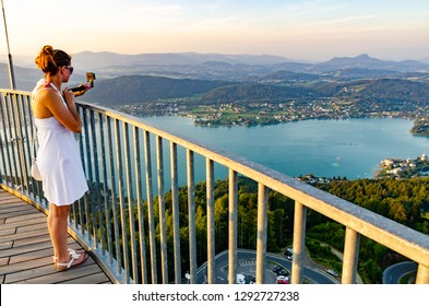 Girl standing on deck of Pyramidenkogel viewing tower in Carinthia. Tourist spot. View at lake and Klagenfurt city