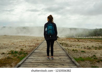 Girl Standing on Hike Path Near Geysers in Yellowstone National Park