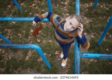 girl standing on monkey bars looking at camera - Powered by Shutterstock