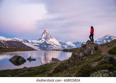 Girl standing on a rock / peak, admiring the Swiss Alps and Matterhorn peak in the background, Zermatt, Stellisee, Switserland