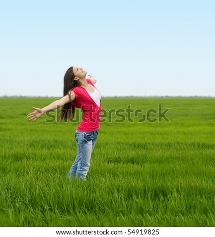 Similar – Junge Frau genießt den Tag auf einem Feld mit Grünflächen.