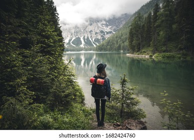 A girl stands in front of a lake in the Dolomites