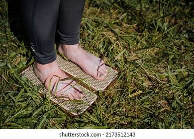 The girl stands with her bare feet on nails, the practice of meditation and fortitude, sharp metal nails, willpower. High quality photo - Shutterstock ID 2173512143