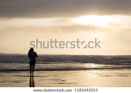 Girl stands looking out at the sea at Olympic National Park in W