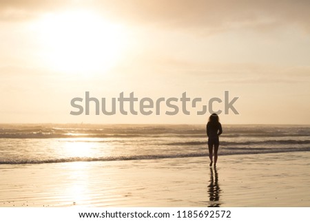 girl stands looking out at the sea at Olympic National Park in W