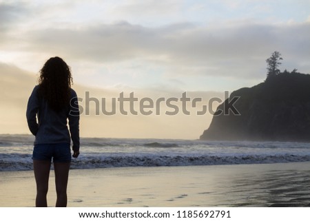 Girl stands looking out at the sea at Olympic National Park in W