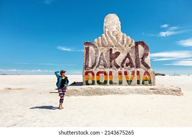 A girl stands near the monument to the Dakar rally in the Salar de Uyuni. Bolivia