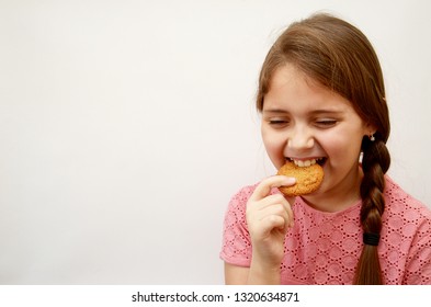 the girl stands on a light background with oatmeal cookies in her hands