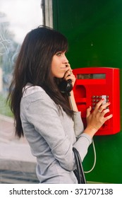 A Girl Stands In A Phone Booth