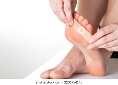 A Girl Sticks A Medical Plaster For Plantar Warts On Her Leg. Callus Treatment. Copy Space For Text, Discomfort