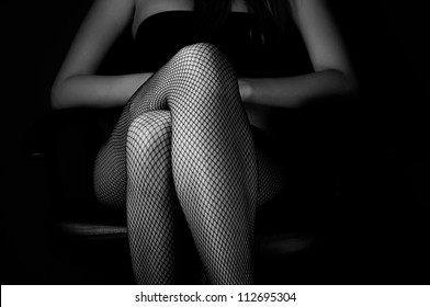 Girl in stockings  against dark background