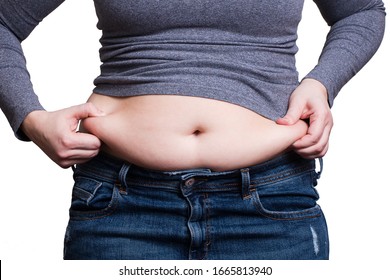 Girl stretches her fat belly in blue jeans and a gray T-shirt isolated on a white background. - Shutterstock ID 1665813940