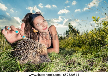 A girl strokes on the nature of a hedgehog
