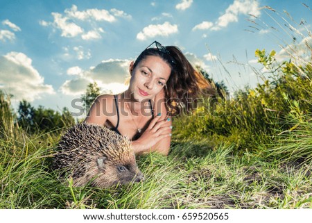 A girl strokes on the nature of a hedgehog