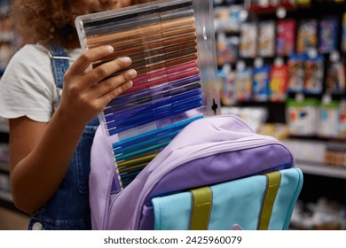 Girl student choosing colorful markers while shopping at stationery store - Powered by Shutterstock