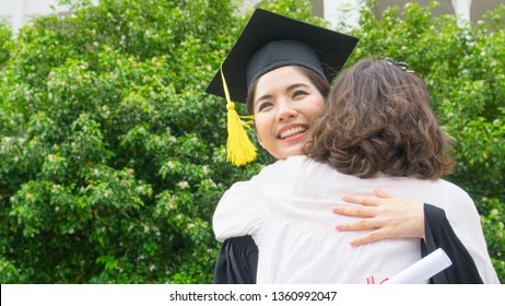 Girl Student With The Graduation Gowns And Hat Hug The Parent In Congratulation Ceremony.