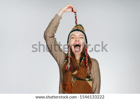 girl in the studio playfully shows tongue and laughs