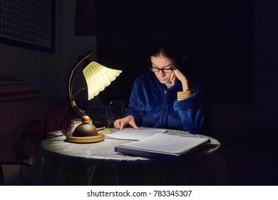 girl studying illuminated by a lamp