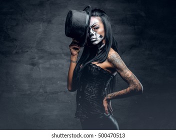 A Girl In Stylish Top Hat With Skull Make Up And Tattoo On Arm. Halloween Party.