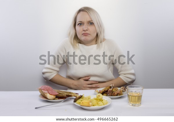 その女の子は腹痛に悩んでいる 消化 腹痛 下痢 便秘 吐き気 不適切な食事 女の子は不健康な脂っこい食べ物を食べる の写真素材 今すぐ編集