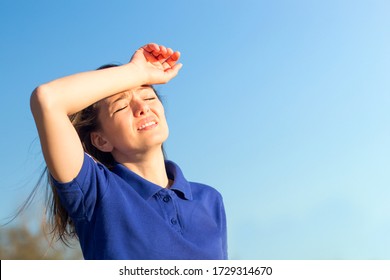 Girl Suffering From Pain, Heat, Woman With Heatstroke. Having Sunstroke At Summer Hot Weather. Dangerous Sun, Girl Under Sunshine. Headache, Feeling Bad. Person Holds Hand On Head. Coronavirus