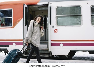 Girl with suitcase that walks along the train station - Shutterstock ID 565907749