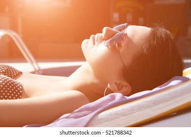 A Girl Sunbathing By The Pool.