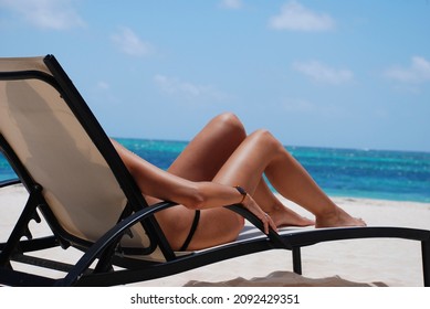 girl sunbathing in chaise lounge on an exotic beach