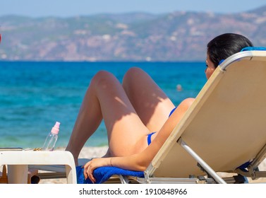 Girl sunbathing on a sun lounger on the beach