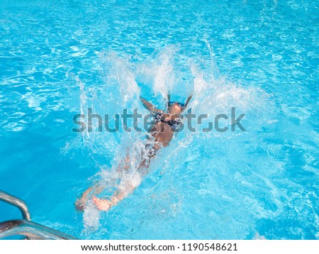 Girl in sunglasses is jumping in the water
